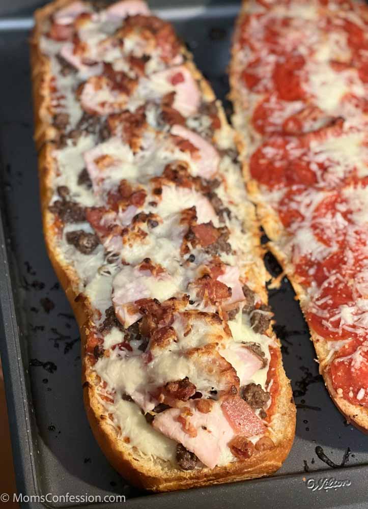 meat lovers french bread pizza on a baking sheet