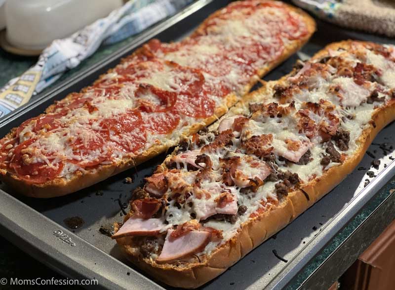 meat lovers and pepperoni french bread pizza on a baking sheet