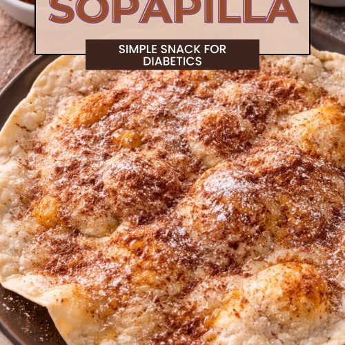 Baked sopapilla topped with cinnamon and a light dusting of powdered sweetener, served on a plate with honey nearby.