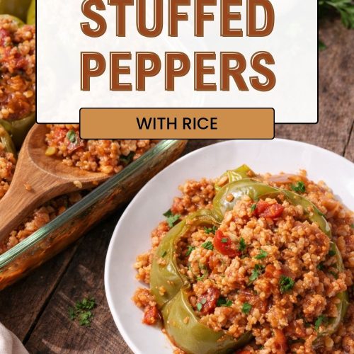 Baked green bell peppers filled with a savory rice and tomato mixture and topped with fresh herbs on a white plate.