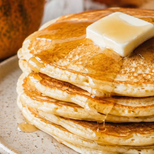 Fluffy homemade pumpkin pancakes topped with butter and maple syrup for an easy fall breakfast recipe
