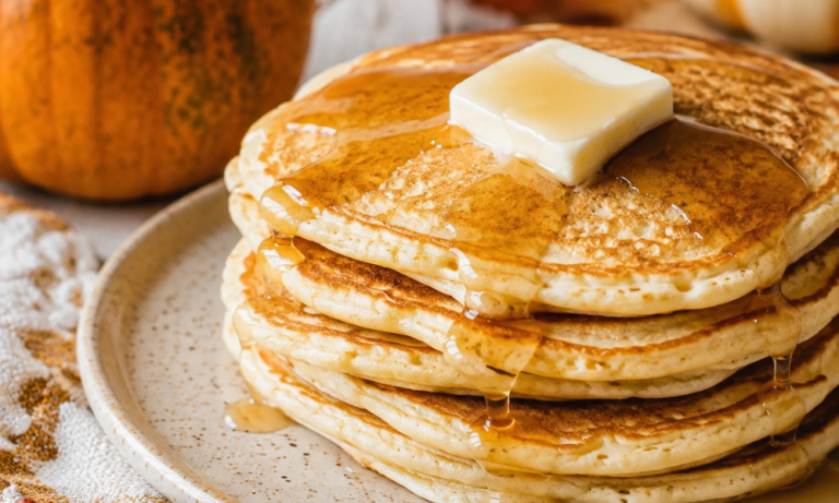 Fluffy homemade pumpkin pancakes topped with butter and maple syrup for an easy fall breakfast recipe