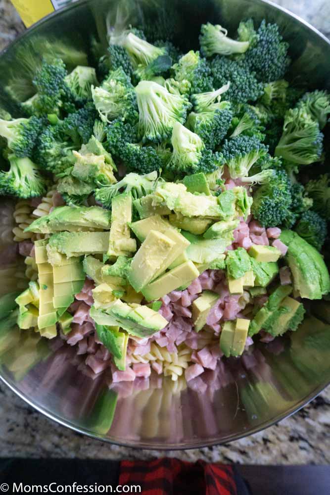 pasta, ham, broccoli and avocado in a large mixing bowl