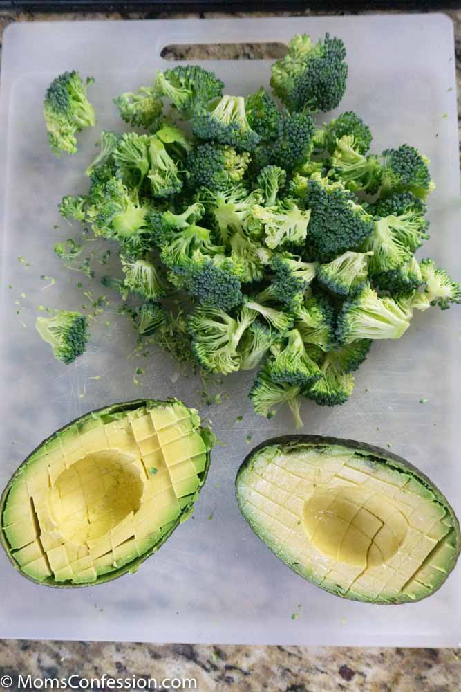 Chopped broccoli and avocado on a cutting board