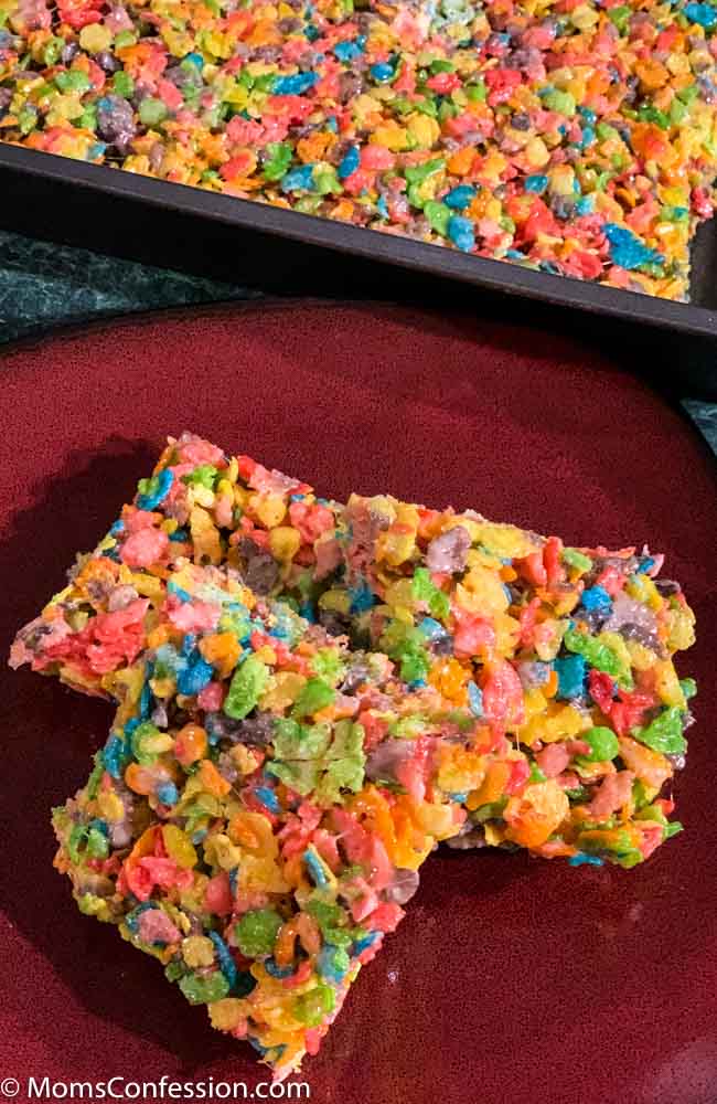 Fruity Pebble Rice Crispy Treats cut into squares on a red plate