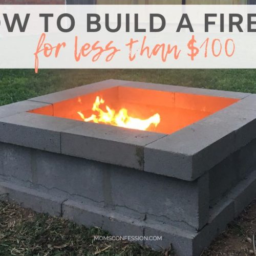 backyard fire pit made from stacked concrete blocks with flames showing in the center