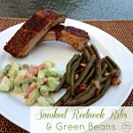 smoked ribs on a plate with cucumber salad and green beans